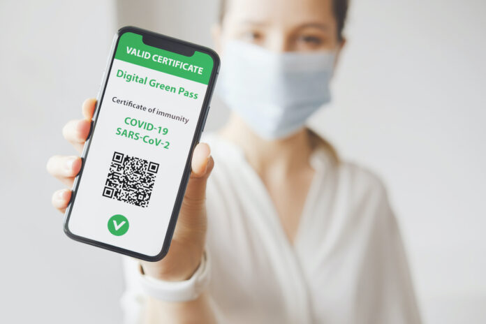 Young,Caucasian,Woman,In,Mask,Holding,Smartphone,With,Digital,Green